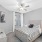 bedroom with bed ceiling fan and wall art