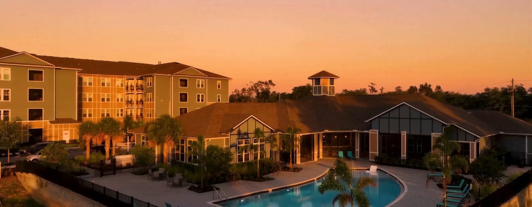 a building with a pool in front at sunrise